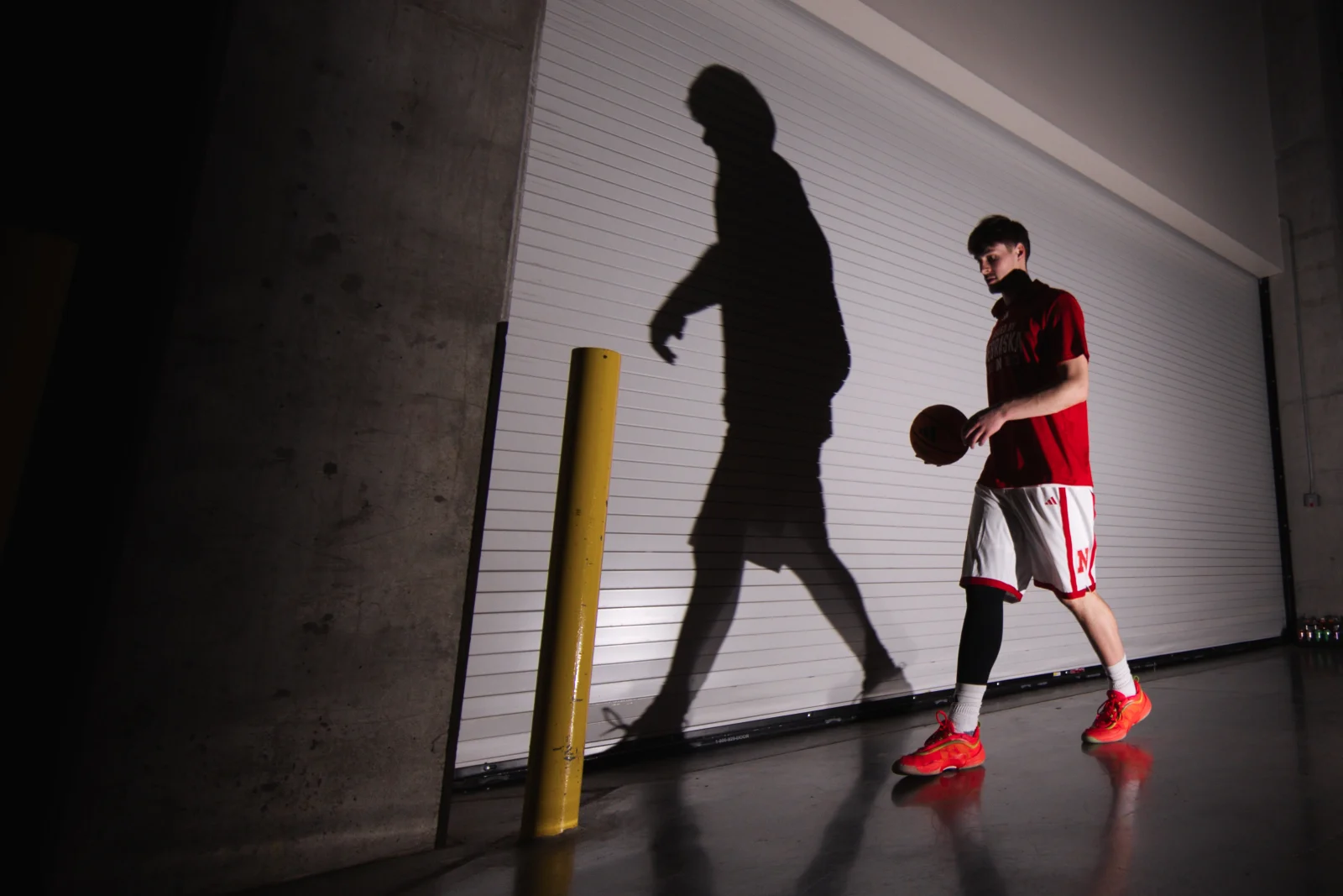Nebraska forward Braden Frager dribbles past his shadow in a tunnel at Pinnacle Bank Arena before a 71-50 win over Creighton in Lincoln, Neb., Sunday, Dec. 7, 2025. The win improved Nebraska to 9-0.