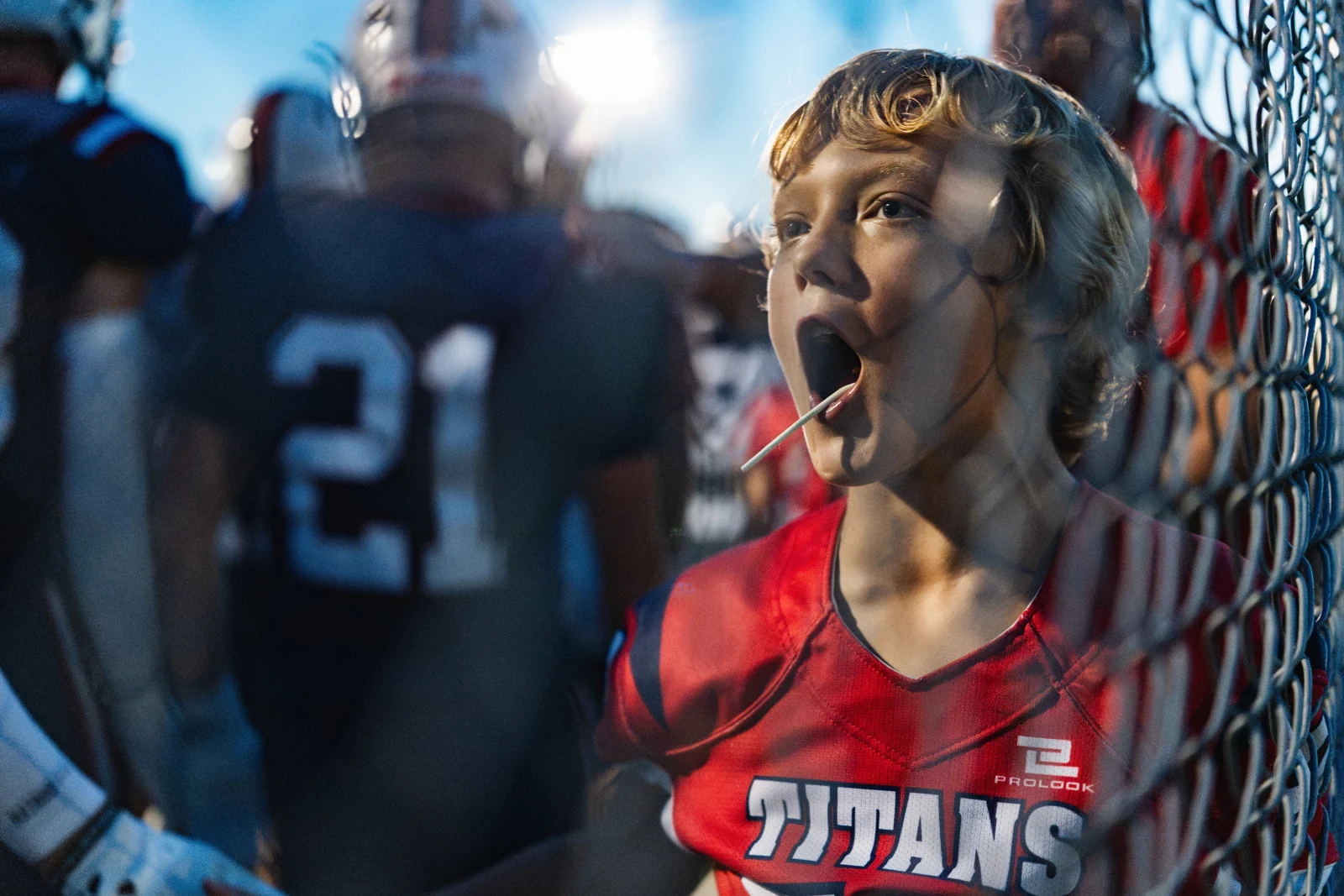 A young fan with a lollipop in his mouth watches open-mouthed as players walk past during a high school football game between Gretna East and host Norris in Firth, Neb., Friday, Aug. 28, 2026.